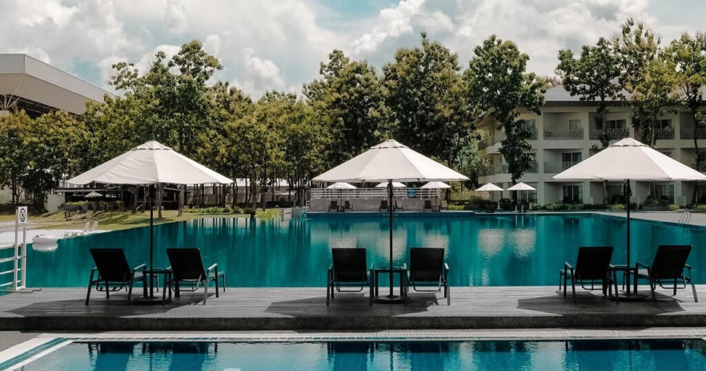 Luxury resort pool with umbrellas and lounge chairs. Hospitality water treatment for clean, safe swimming.