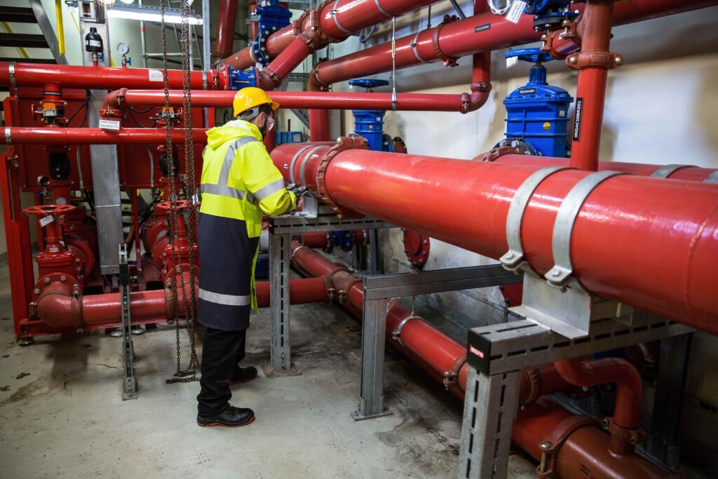 technician fixing industrial plumbing pipes